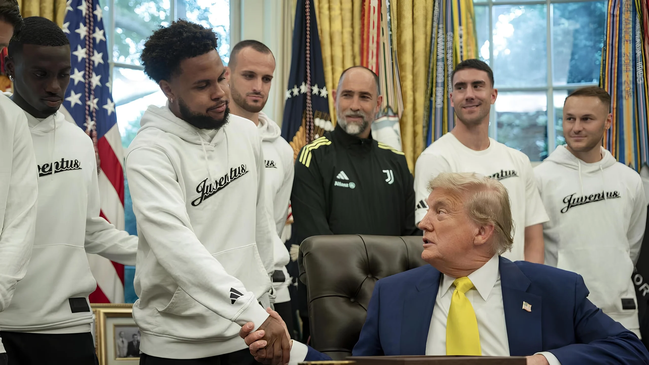 Scena surreale alla Casa Bianca: Trump parla di guerra e trans con la Juve alle spalle